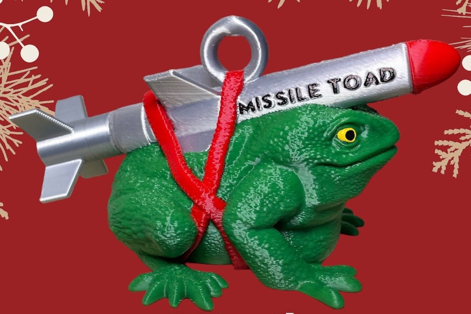 Decorative ornament of a green toad with a missile on a red background